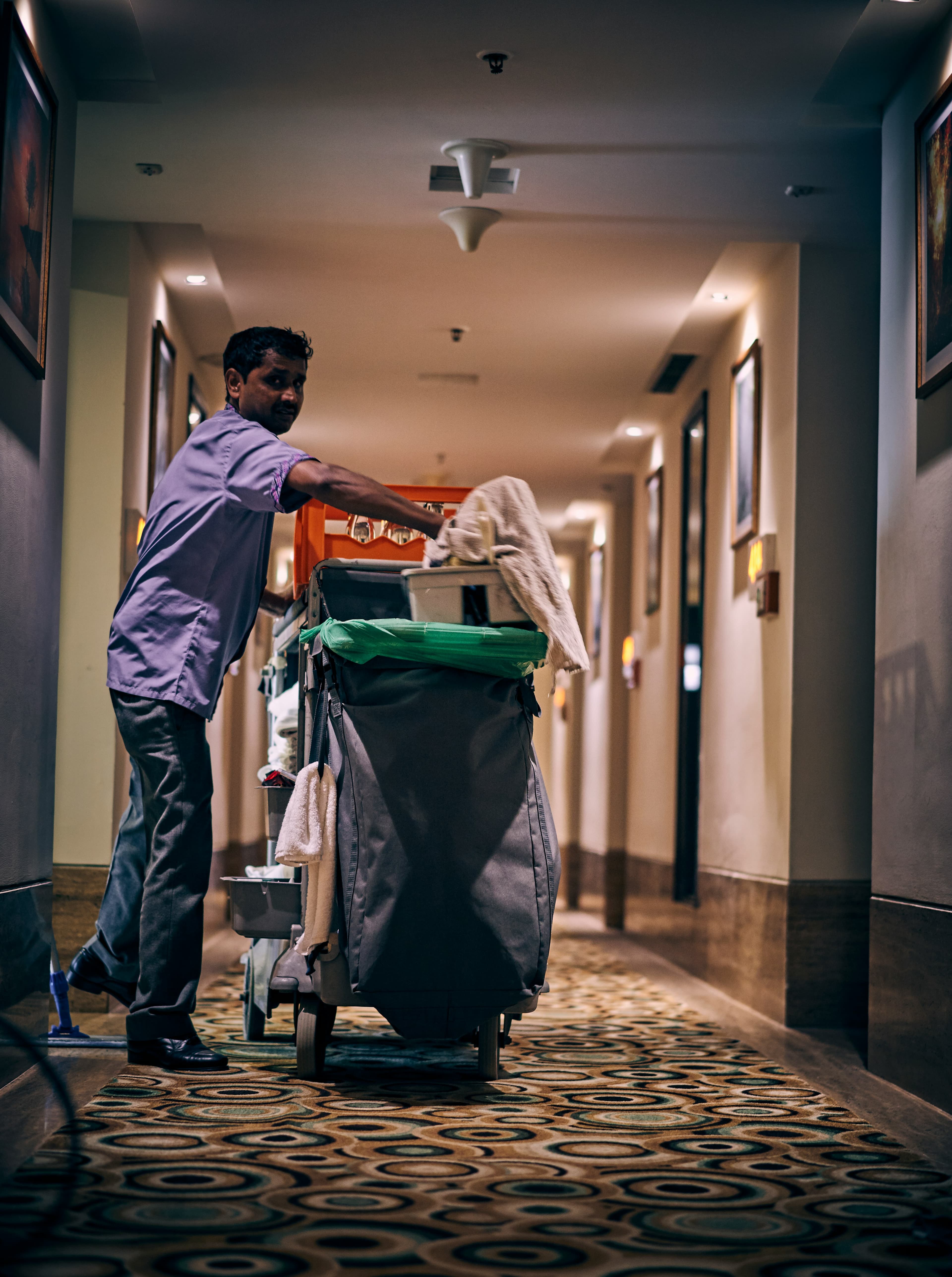 Professional cleaner maintaining a commercial interior with cleaning equipment